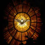 A vertical view of the dove of the Holy Spirit on the stained glass in St. Peter's Basilica