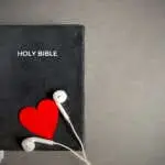 Bible with earphones and red heart  Symbolises devotion and love for hearing God's words. Christianity concept.