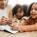 Bible, worship or grandmother praying with kids or siblings for prayer, support or hope in Christianity. Children education, family or old woman studying, reading book or learning God in religion