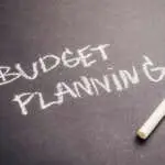 Budget Planning text, handwriting with chalk on black paper