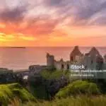 Bushmills, Antrim, Northern Ireland, Aug 2019 Sunset at ruins of Dunluce Castle located on the edge of cliff, Bushmills, Northern Ireland. Filming location of popular TV show Game of Thrones