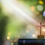 Christmas bright light background with bible and crucifixion of Jesus Christ and lights bokeh background