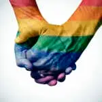 closeup of a gay couple holding hands, patterned as the rainbow flag