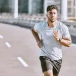 Exercise, workout and training with a healthy man training for sport, fitness and wellness outside in the city. Running, exercising and working out with motivation for lifestyle, health and sports