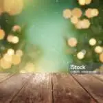 Festive wooden table background with christmas tree lights.