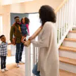Happy african american family welcoming father coming back home. family time, having fun together at home.
