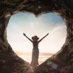International human rights day concept: Silhouette alone woman standing on cave of heart and meadow sunset background