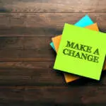 Make A Change, the phrase is written on multi-colored stickers, on a brown wooden background. Business concept, strategy, plan, planning.