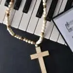 Religious music background for piano with instrument and sheet music with crosses on top on black table. Top view.