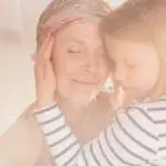 Small caring child embracing mother suffering from leukemia