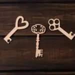 Three wooden keys on a dark background