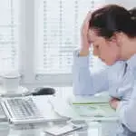 tired business woman with computer in the office, stress and problems, feeling regret and guilty