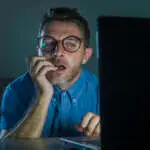young lascivious and aroused porn addict man in nerd glasses watching sex movie online late night at laptop computer looking pervert and horny in internet pornography and sex content
