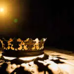 The crown on a black background is illuminated by a golden beam. Low-key image of a beautiful queen / royal crown Vintage is filtered. Fantasy of the medieval period. Battle for the Throne.