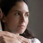 Close up of pensive woman hug man feel skeptical look in distance think of cheating in relationships. Suspicious unfaithful female embrace husband pondering of marriage problems or family troubles.