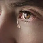 Closeup of young crying man eyes with a tears. High quality photo